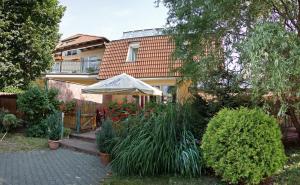 una casa con un ombrello e qualche pianta di Penzión Alberto a Prievidza