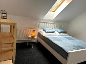 Un dormitorio con una cama con almohadas azules y una mesa. en BREZA HOUSE apartments, en Zlín
