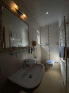 a bathroom with a sink and a toilet at Haus Ohio Garni in Borkum