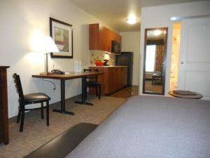 een kamer met een bed, een bureau en een keuken bij Ledgestone Hotel Billings in Billings