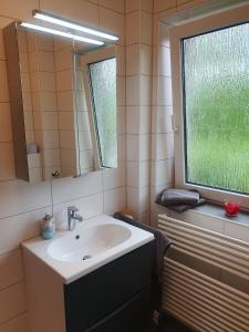 La salle de bains est pourvue d'un lavabo, d'un miroir et d'une fenêtre. dans l'établissement Mövenschiss, à Wremen
