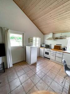 a kitchen with white appliances and a large window at Hyggeligt anneks på Thurø, tæt på vandet. in Svendborg