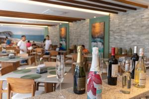 two bottles of wine sitting on a table in a restaurant at Praia de Muro Alto Mana Beach 003 C in Porto De Galinhas