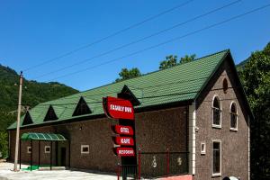 a large brick building with a green roof at Family Inn in İsmayıllı