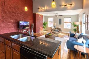 a kitchen with a sink and a living room at Broadway Suites - Stunning Downtown Condos in Cincinnati
