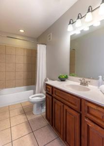 bagno con lavandino, servizi igienici e specchio di Broadway Suites - Stunning Downtown Condos a Cincinnati