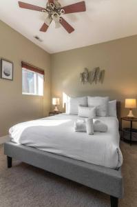 sypialnia z dużym białym łóżkiem i wentylatorem sufitowym w obiekcie Broadway Suites - Stunning Downtown Condos w mieście Cincinnati