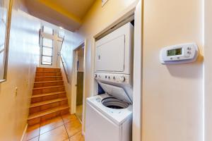 a washer and dryer in a room with a staircase at Palm Beach Club 2-225 in Pensacola Beach