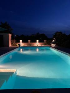 a large blue swimming pool at night at Holiday House Serenity in Malinska