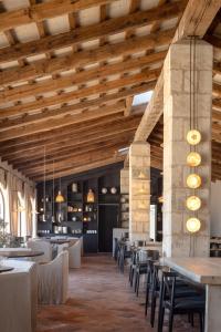 a restaurant with wooden ceilings and tables and chairs at Vestige Son Vell in Ciutadella