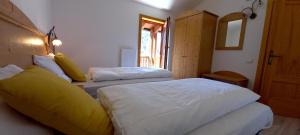 a bedroom with two beds and a window at Locanda Val Canali in Siror