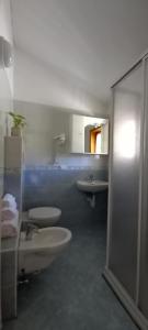 a bathroom with two toilets and a sink at Locanda Val Canali in Siror