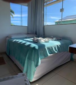 uma cama num quarto com uma janela em Bougainville Suítes em Arraial do Cabo