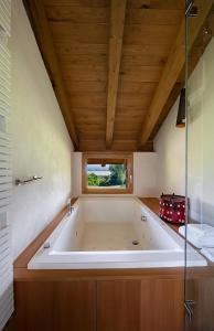 a large bath tub in a room with a wooden ceiling at La Cucchetta in Dormelletto