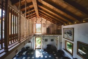 Habitación grande con techos de madera y ventanas en una casa. en La Cucchetta, en Dormelletto