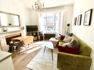 ロンドンにあるThe Barnsbury, London Apartment with WIFIのリビングルーム(緑のソファ、テーブル付)