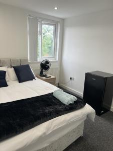 a bedroom with a large bed and a window at Deluxe En-Suite Bedroom In the Centre of Watford in Watford