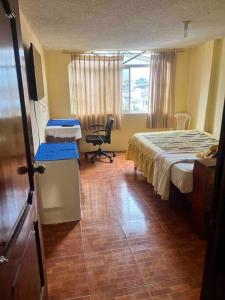 um quarto com uma cama, uma secretária e uma cadeira em Ventana al Pedacito de Cielo em Baños