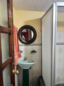 uma pequena casa de banho com um lavatório e um espelho em Ventana al Pedacito de Cielo em Baños