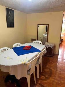 uma sala de jantar com uma mesa e quatro cadeiras em Ventana al Pedacito de Cielo em Baños