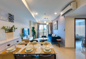 een eetkamer en een woonkamer met een tafel en stoelen bij S Lux Apartment in Ho Chi Minh-stad