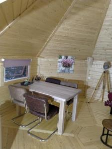 a table and chairs in a room with wooden walls at Kota Wadway in Spanbroek