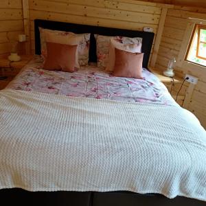 a bedroom with a large bed with a white comforter at Kota Wadway in Spanbroek