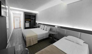 una camera d'albergo con letto e tavolo di Dall’Onder Grande Hotel Bento Gonçalves a Bento Gonçalves