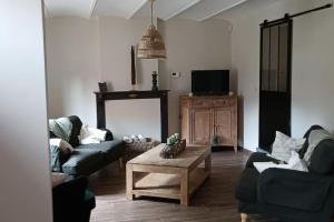 a living room with two couches and a coffee table at Les roses d'Olga in Aubechies