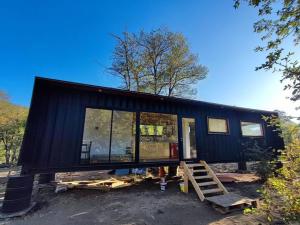 a black tiny house is being built at Hermosa vista y casa acogedora in Pinto