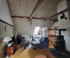 ein Wohnzimmer mit einem Sofa und einem Herd in der Unterkunft Kreativgård Hoge in Højer