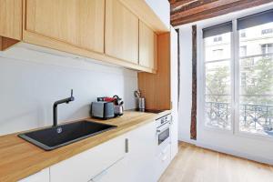 a kitchen with a sink and a window at Studio 2P rénové rue des Archives Marais Clim 3 in Paris