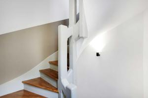 a staircase in a house with white walls and wooden floors at Studio 2P rénové rue des Archives Marais Clim 3 in Paris