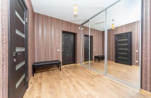 a hallway with glass doors and wooden floors at Apartment on Draghomanova 2a in Kyiv