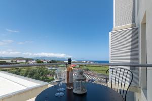 un tavolo con 2 bicchieri da vino sul balcone di Belavista Oceanside a Ribeira Grande