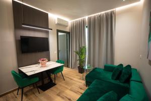 a living room with a green couch and a table at Vlore Luxury Apartaments "FAEL" in Vlorë