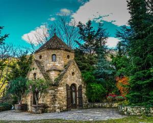 a large stone building in the middle of a forest at PeMel Grand apartment in Aíyira