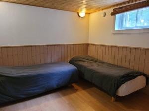a room with two beds and a window at Rauhallinen asunto maalla, navetan päädyssä. in Muurame