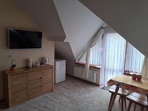 a living room with a tv and some windows at Willa Małgorzata pod skocznią in Zakopane