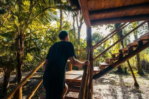 um homem a descer as escadas de uma cabana em Cabana na árvore na Bahia! Para viver uma experiência de hospedagem pertinho da praia em Maraú