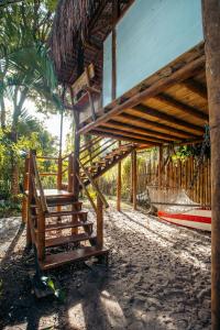 um alpendre de uma casa com um baloiço em Cabana na árvore na Bahia! Para viver uma experiência de hospedagem pertinho da praia em Maraú