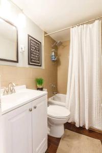 a bathroom with a toilet and a sink and a tub at Spacious Home Walk to Everything and FREE Parking in Cincinnati
