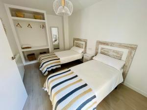 Un dormitorio con dos camas y un espejo. en Apartamento El Sereno, en Teruel
