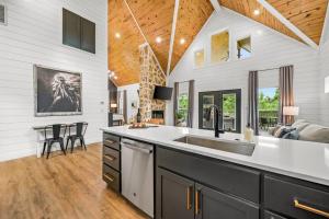 a kitchen with a sink and a living room at Double Arrow Cabin in Broken Bow