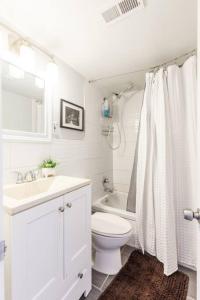 a white bathroom with a toilet and a sink at OTR Penthouse Walk Everywhere FREE Parking in Cincinnati