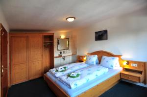a bedroom with a large bed with a wooden headboard at Pferdehof Oberegg in Werfenweng