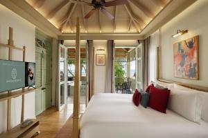 a bedroom with a bed with a ceiling fan at Charras Bhawan Hotel and Residences in Hua Hin