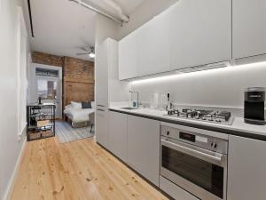 uma cozinha com armários brancos e um forno com placa de fogão em Over the Rhine Luxury MicroSuite On Findlay Market em Cincinnati