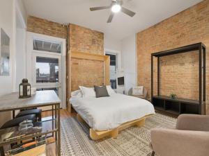 um quarto com uma cama e uma parede de tijolos em Over the Rhine Luxury MicroSuite On Findlay Market em Cincinnati