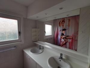 a bathroom with two sinks and a large mirror at Izzy's Rainbow House in De Haan